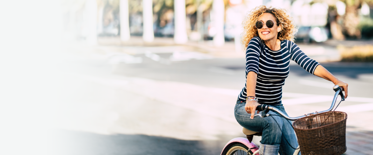 Banner image of happy lady moving freely, riding a bike